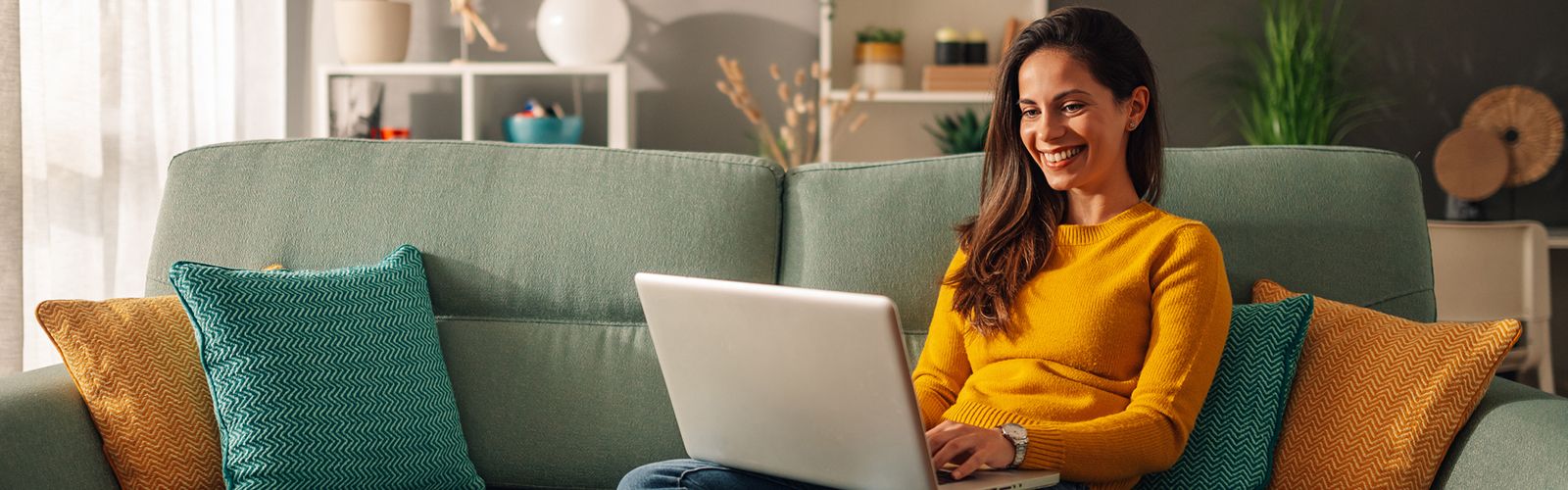 a woman using laptop while sitting on a couch